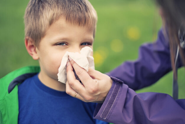 Mother cleaning nose of sick son